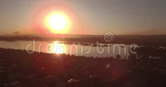 空中观景日落在湖面上海岸上有一个小城市工业工厂在地平线上4K视频的预览图