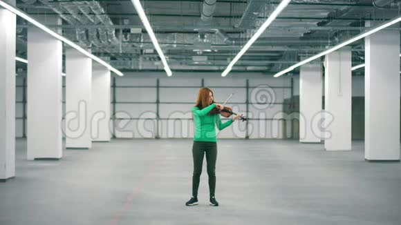 女音乐家正在空厅里拉小提琴视频的预览图