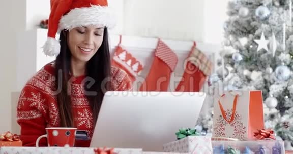 微笑的女人在网上做圣诞购物视频的预览图