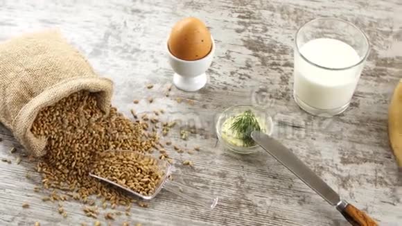 一堆小麦牛奶鸡蛋黄油和新鲜面包放在乡村木桌上乡村早餐视频的预览图