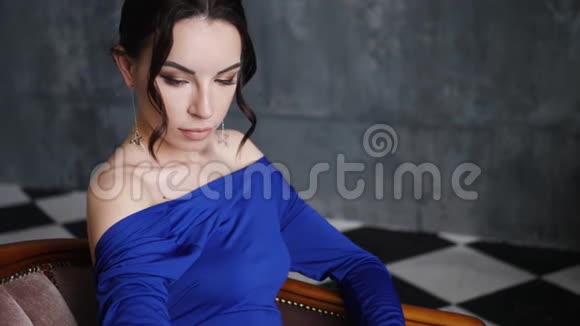穿蓝色长裙的女孩躺在旧沙发上视频的预览图