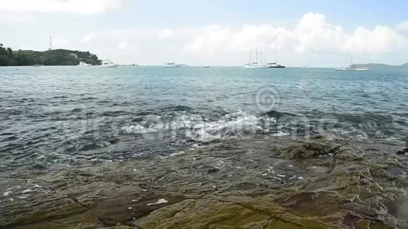 在敖延海滩的海岸线风光波浪在低角度的岩石上冲刷安达曼海与游艇视频的预览图
