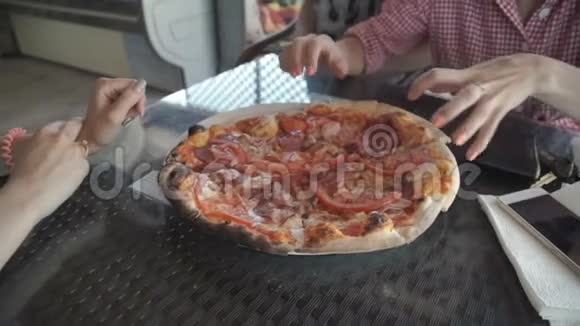 女性手从桌子上的盘子里拿披萨从上面看一群饥饿的人欧洲街头视频的预览图