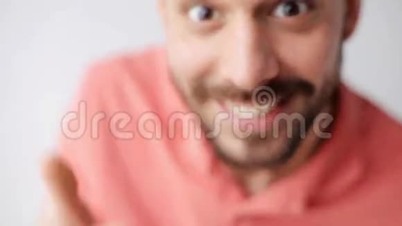 带胡子的快乐微笑男人在镜头前玩视频的预览图