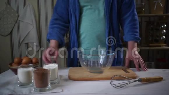 厨师烹饪在玻璃碗里加入巧克力蛋糕的原料视频的预览图