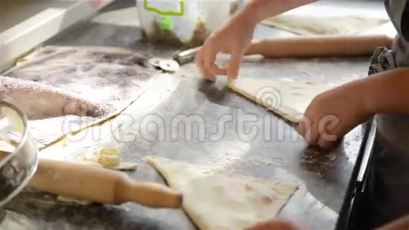 两个厨师在一个专业的厨房里处理面团和煮熟的馅饼视频的预览图