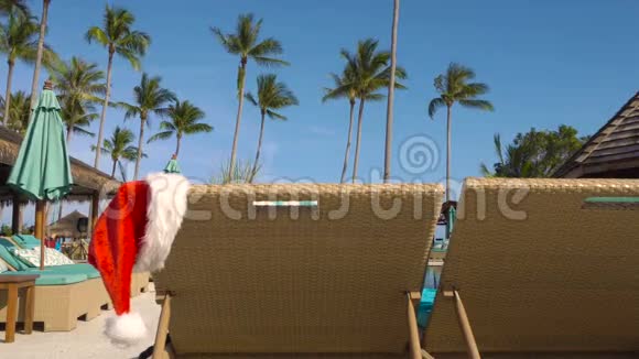 圣诞老人帽子挂在日光浴床上视频的预览图