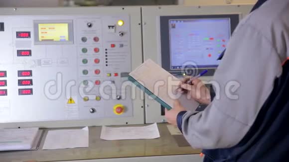 工程师在工业工厂控制面板上控制参数书写指征测量成垫滑块视频的预览图
