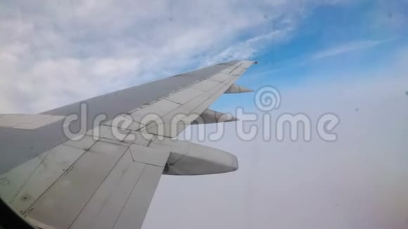 一架客机在云层上方低空飞行的机翼上的窗口视图视频的预览图