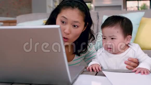 妈妈带着哭泣的宝宝用笔记本电脑视频的预览图