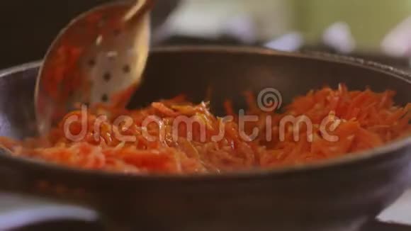 生胡萝卜是用葵花籽油在煎锅里煎的素食主义者室内烧烤胡萝卜视频的预览图