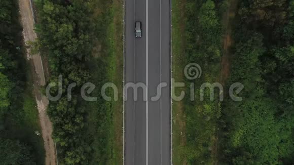 从乡村道路上方透过绿色森林俯瞰空中景色视频的预览图