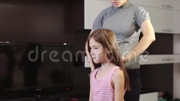 一个漂亮的女人编她小女儿的辫子在头上编辫子视频的预览图