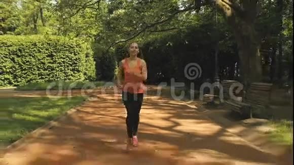 在美丽的夏日阳光下慢跑的女人在城市公园里奔跑视频的预览图