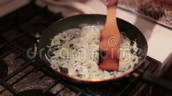 将女性搅拌洋葱放入平底锅中煎煮晚餐视频的预览图