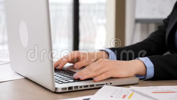 女人在办公室里用笔记本电脑键盘打字视频的预览图
