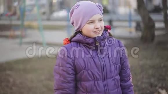 戴着牙套的小女孩在春天公园里笑得很可爱视频的预览图
