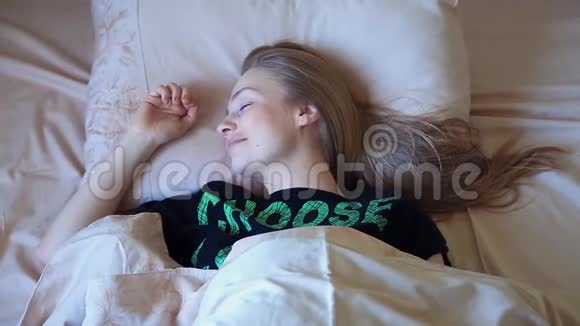 清晨躺在床上的漂亮金发女人视频的预览图
