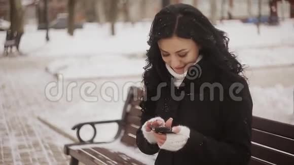 在公园的长椅上写短信的女孩视频的预览图