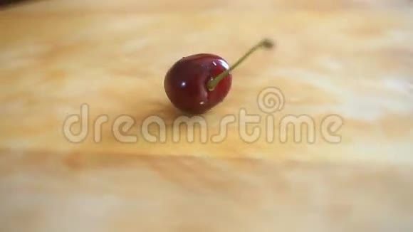 一颗樱桃躺在木板上木板绕着它的轴旋转视频的预览图