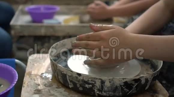 年轻的小学生试图在车间的陶轮上做一个陶瓷碗视频的预览图