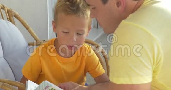孩子和父亲在阳台上看书视频的预览图