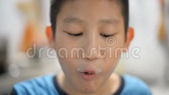 亚洲男孩在厨房喝茶果汁或热巧克力视频的预览图