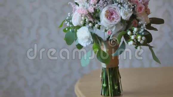 婚礼上一束五颜六色的新娘花粉红色白色玫瑰和黄色的自由女神躺在桌子上视频的预览图