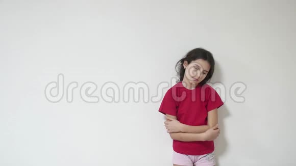 女孩孩子悲伤孤独沮丧站在墙边拥抱自己视频的预览图