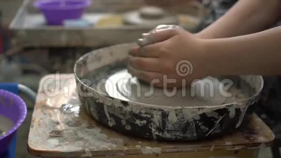 年轻的陶工试图在车间的陶轮上做一个碗视频的预览图