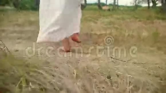 没有鞋子的女人在草地上漫步视频的预览图