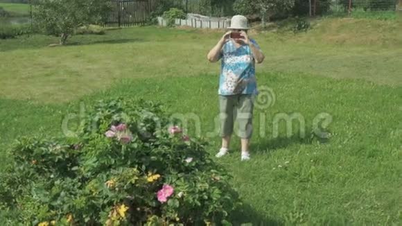年迈的祖母在公园里拍照视频的预览图
