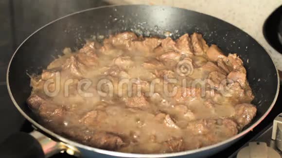 在煎锅里炖肉肉在自己的果汁中沸腾视频的预览图