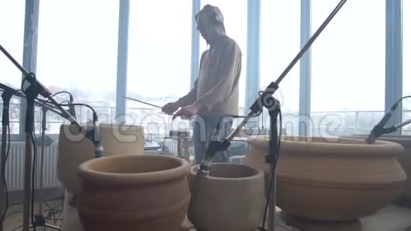 穿着运动衫的男人在陶罐上播放概念音乐视频的预览图