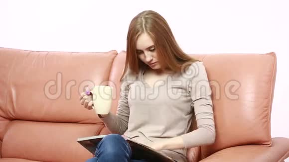 沙发上拿着杯子的翁美女画像视频的预览图