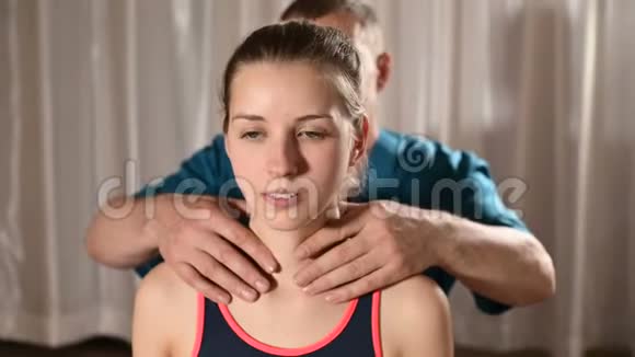 男性手动内脏治疗师按摩师治疗年轻女性患者为肩膀和脖子热身视频的预览图