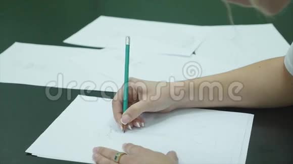 人类用铅笔在白色桌子背景的纸上画连衣裙视频的预览图