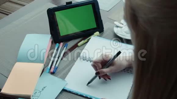 自由职业者女孩在咖啡馆工作使用触摸板和绿色屏幕视频的预览图