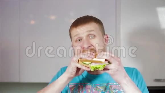 年轻人在厨房吃三明治视频的预览图