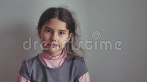 少女在灰色背景的室内微笑生活方式视频的预览图
