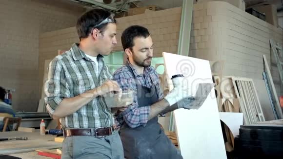 两个木匠在讨论工作其中一个在吃饭视频的预览图