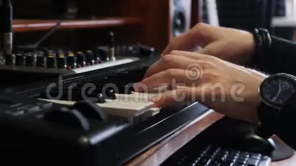 双手用数字手表在钢琴电子键盘上弹奏音乐录音室概念音乐家在录音室制作歌曲视频的预览图