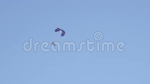 带马达的降落伞在蓝色多云的天空上飞行视频的预览图