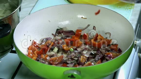 把切成薄片的小番茄和洋葱和辣椒扔进锅里视频的预览图
