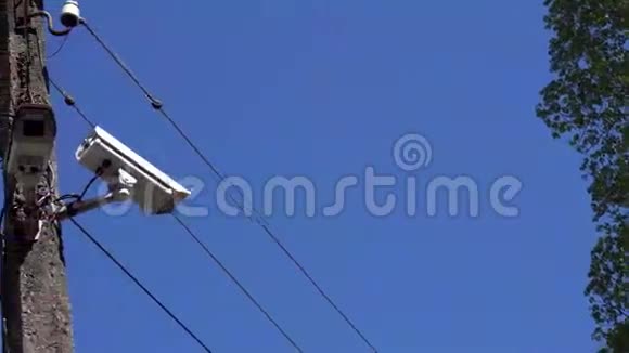 闭路电视摄像机挂在蓝天背景上的电线杆上视频的预览图