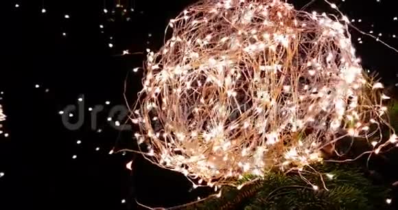 抽象圣诞闪光灯球在圣诞树上黑色背景上有温暖的火花金色节日圣诞节的概念视频的预览图