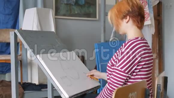 一位年轻的艺术家在一个艺术工作室里用铅笔从大自然中画出一幅素描的静物视频的预览图