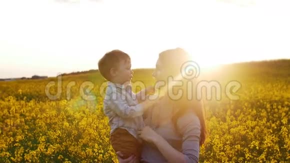 日落时分母亲和儿子在田里玩耍慢节奏视频的预览图