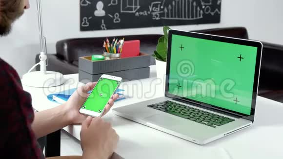 用绿色屏幕关闭手握智能手机铬钥匙闭上雄性手在细胞上滚动图片视频的预览图