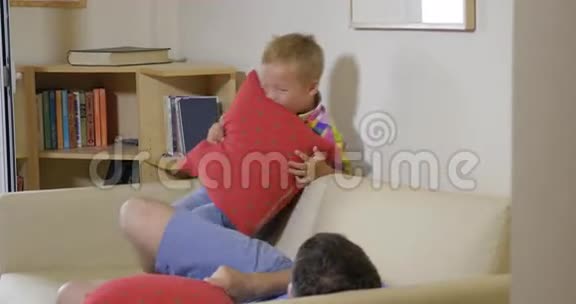 儿子和爸爸在家里抱枕头打架视频的预览图